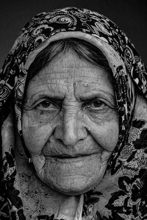 Photo by Linda M, - Black and white portrait of a smiling elderly woman  with gray hair in a floral dress