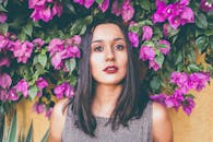 这幅女性肖像引人注目，四周环绕着鲜艳的九重葛花