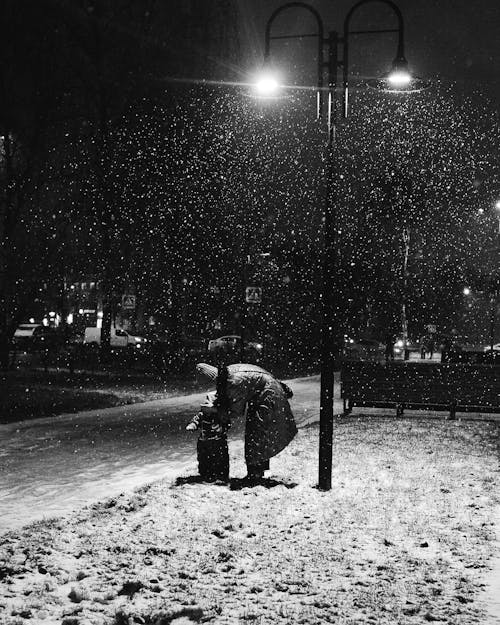 Woman with a Little Child on a Pavement at Snowfall 