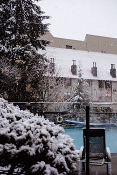 A snowy winter day in Whistler, BC, Canada with a pool amidst the snow-covered landscape.