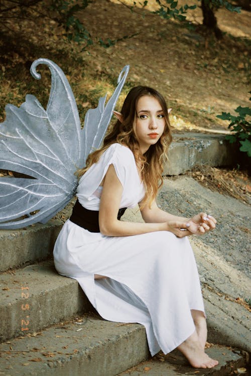 Free Woman Sitting on Stairs with Wings Stock Photo
