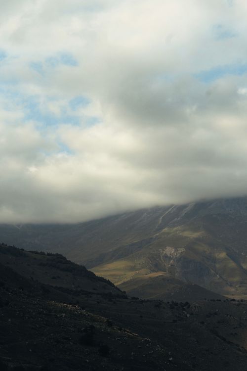 Free Breathtaking view of mist-covered mountains under a cloudy sky in the Caucasus region, Russia. Stock Photo