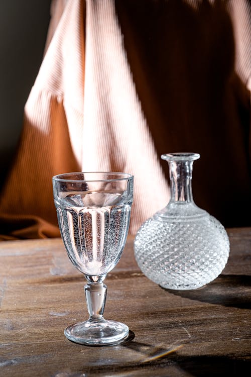 Free Glass with Water and Carafe on a Table Stock Photo
