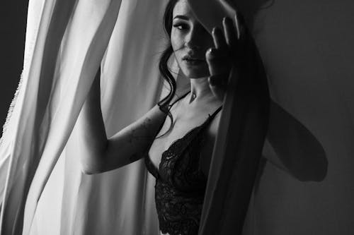 Woman in Black Lace Brassiere Standing Near the Curtain