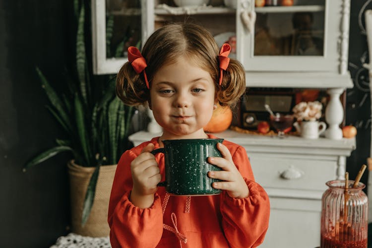 Girl In Red Long Sleeve Dress Holding Green Ceramic Mug