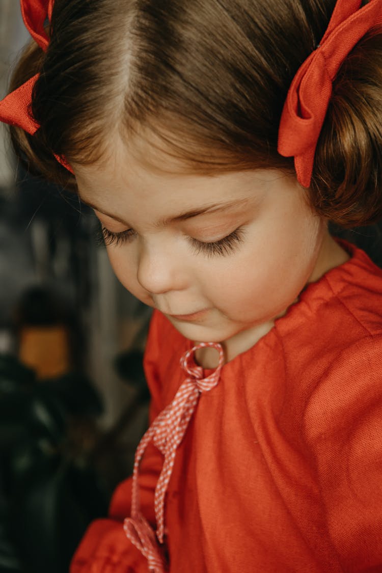 Portrait Of Girl In Red Dress With Ribbons In Hair