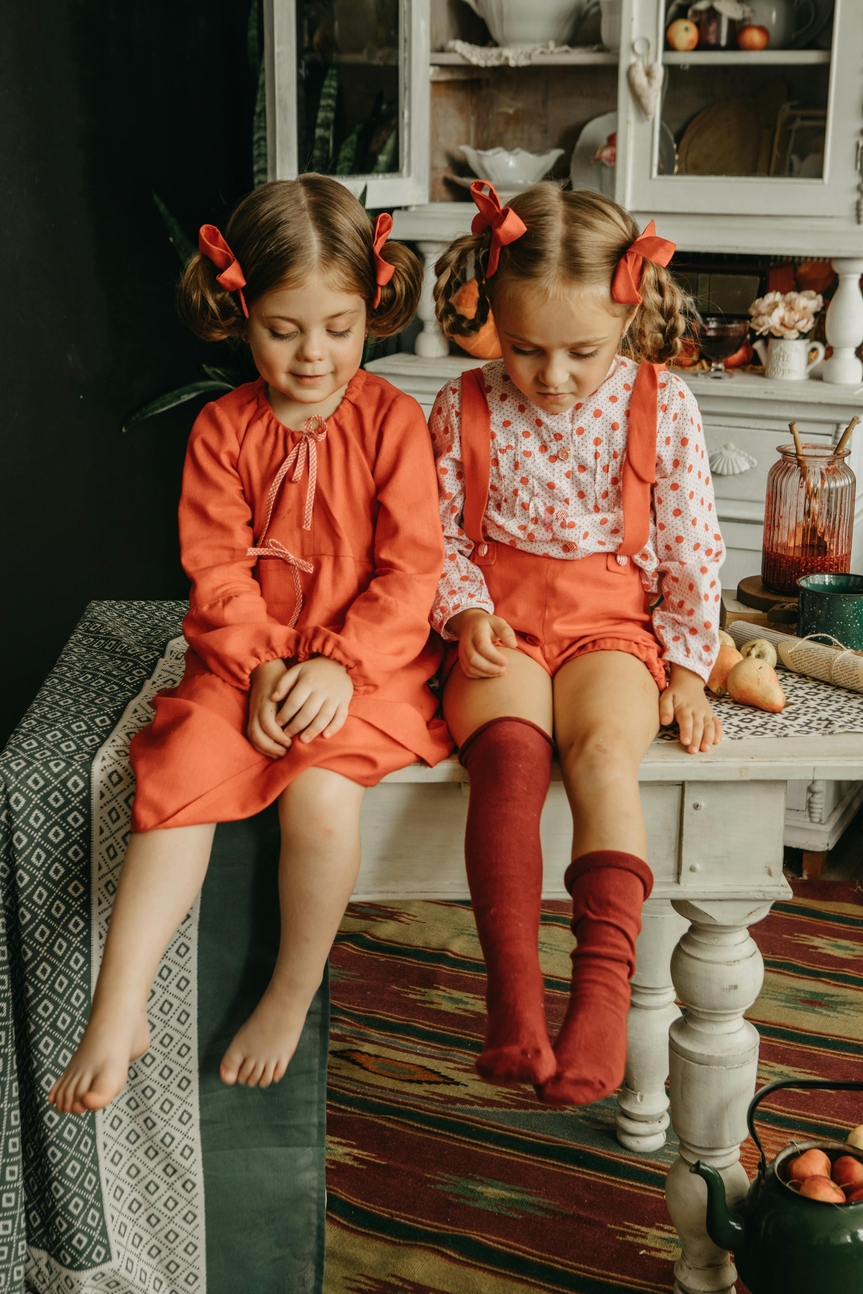 Girls with Ribbons in Hair Sitting on Antique Kitchen Table · Free