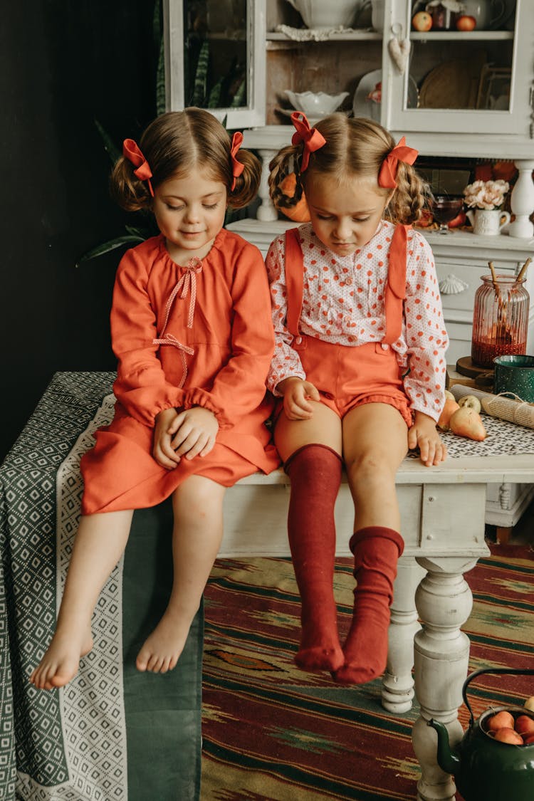 Girls With Ribbons In Hair Sitting On Antique Kitchen Table