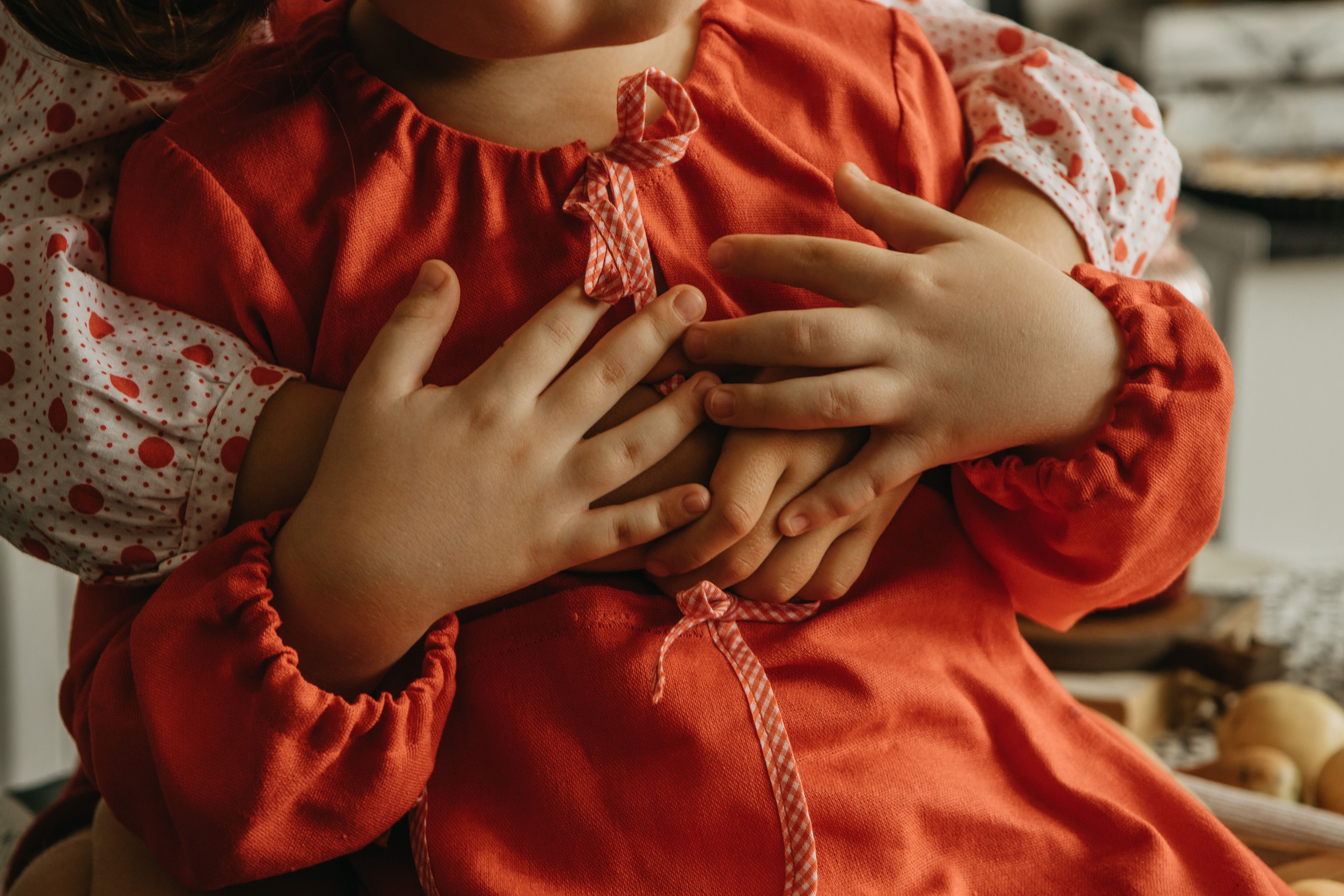 Intimate close-up of children embracing, showcasing warmth and affection in a soft, cozy setting.