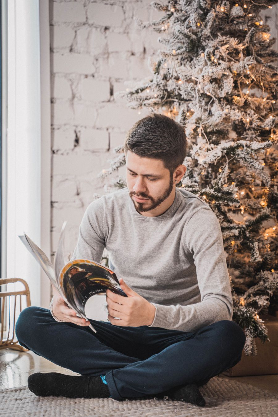 Man som läser en tidning vid en julgran