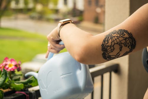 Person Holding Gray Plastic Watering Can