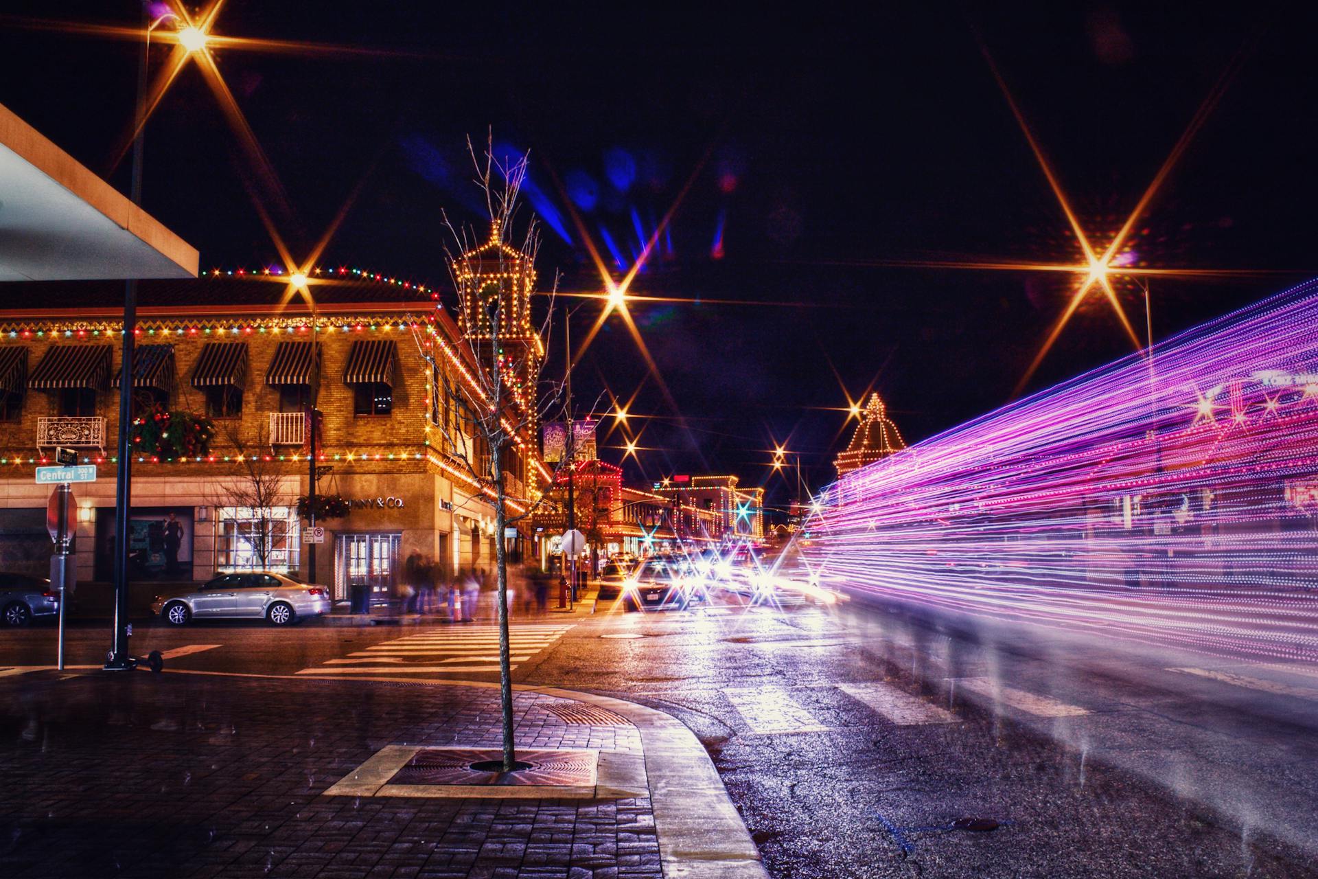 Long exposure captures the lively night scene of Kansas City with colorful lights and bustling streets.