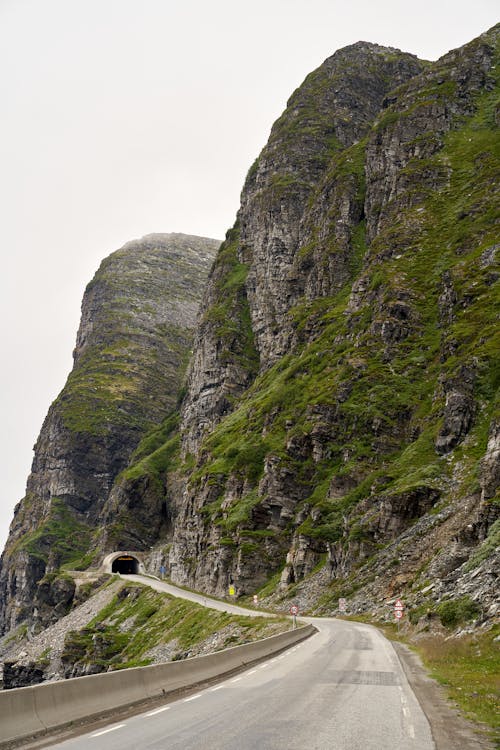 Free Road on a Cliff Side Going into Tunnel  Stock Photo