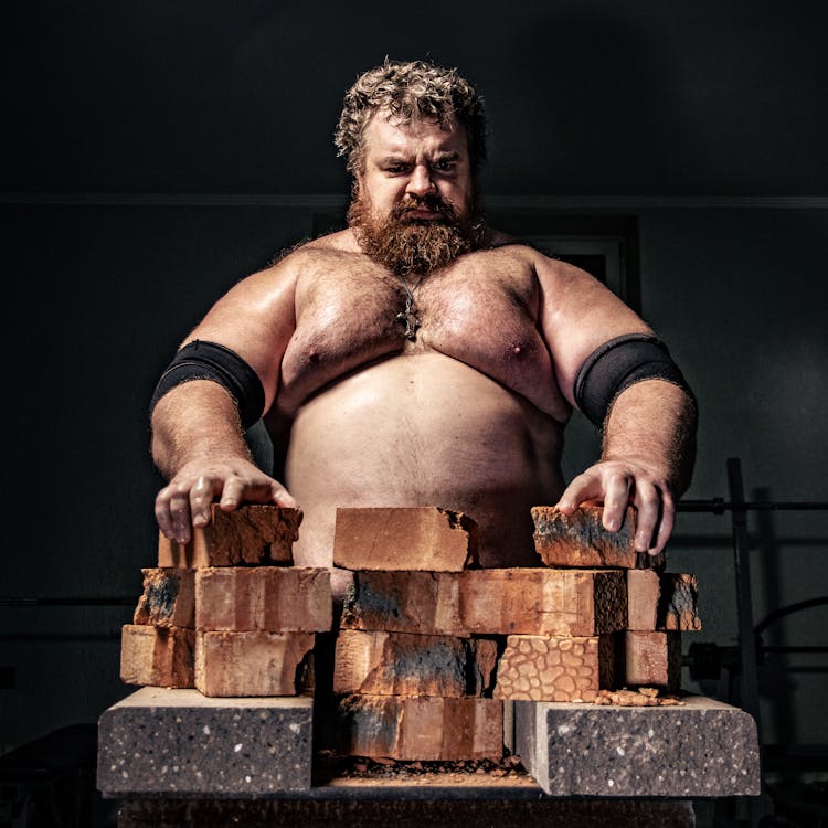 Portrait Of A Shirtless Strongman Handling Wooden Blocks