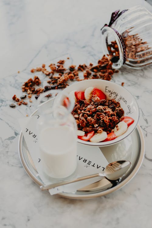 Glass of Milk and Bowl of Cereals on Ceramic Plate