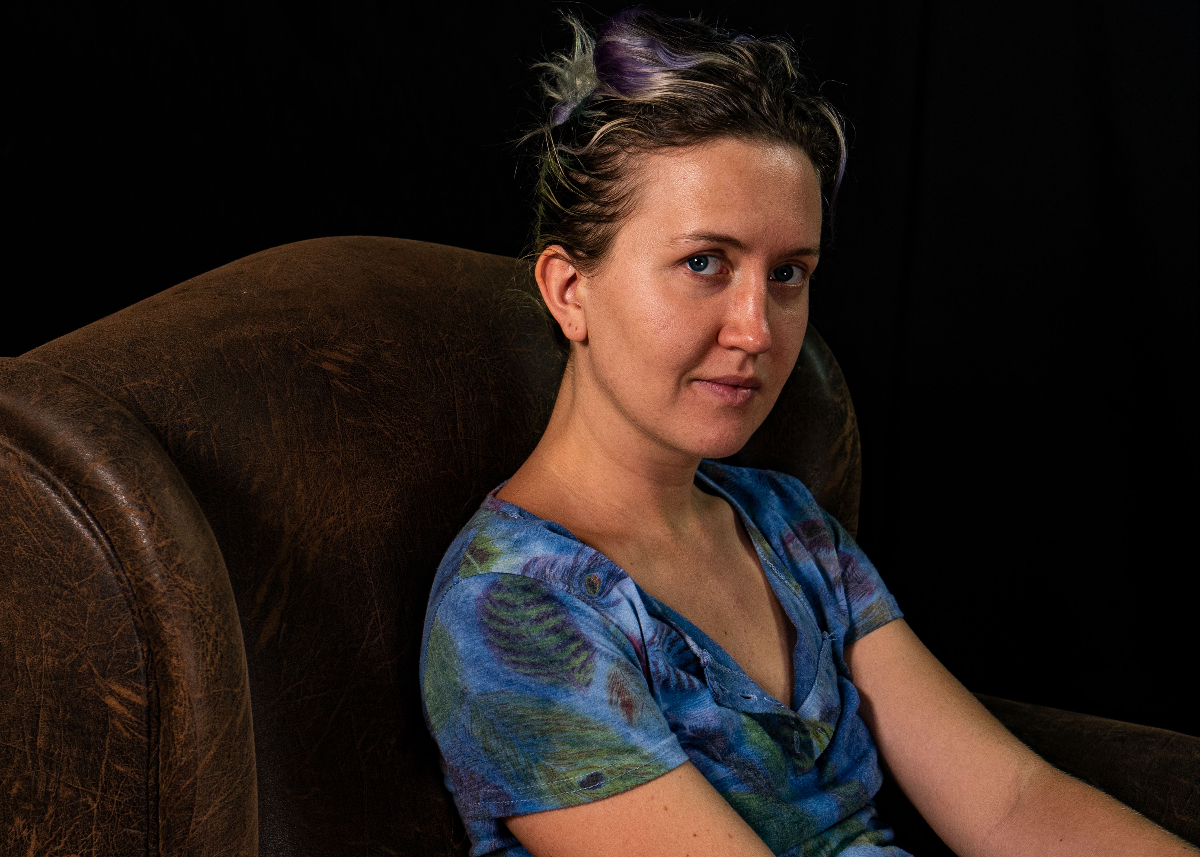 Woman in a Blue Shirt Sitting on a Leather Chair · Free Stock Photo
