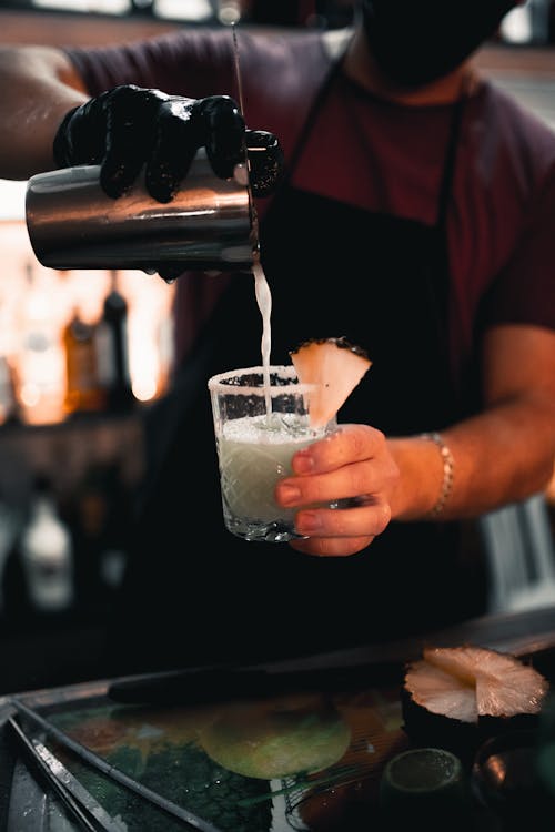 Photo of a Bartender Pouring Liquid into a Glass