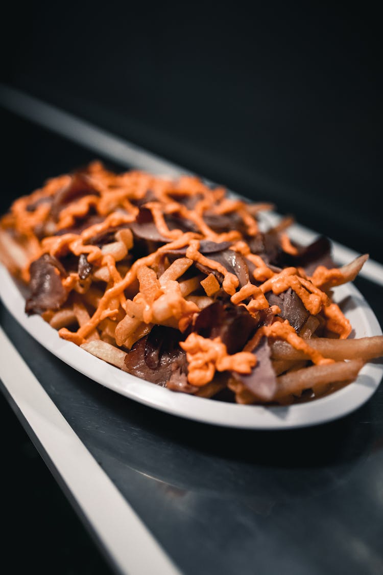 A Plate Of Fries With Meat And Cheese