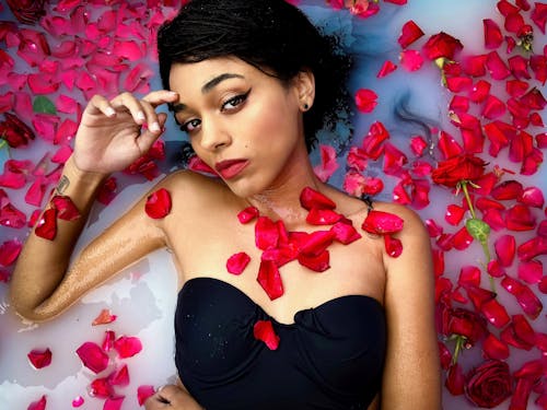 Free Woman in Black Tube Top Lying on Red Petals Stock Photo
