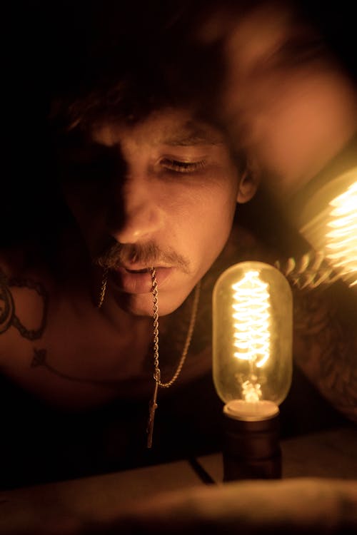Portrait of a Man beside a Light Bulb