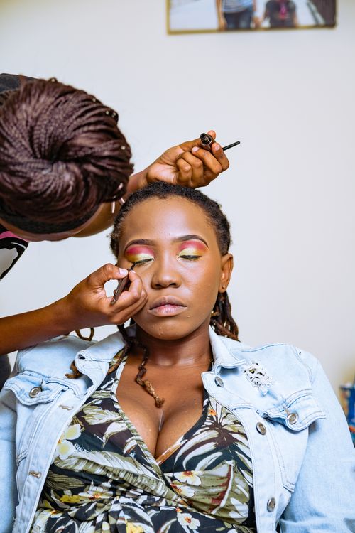 Free Woman with eyes closed having eye makeup applied, capturing a serene beauty session. Stock Photo