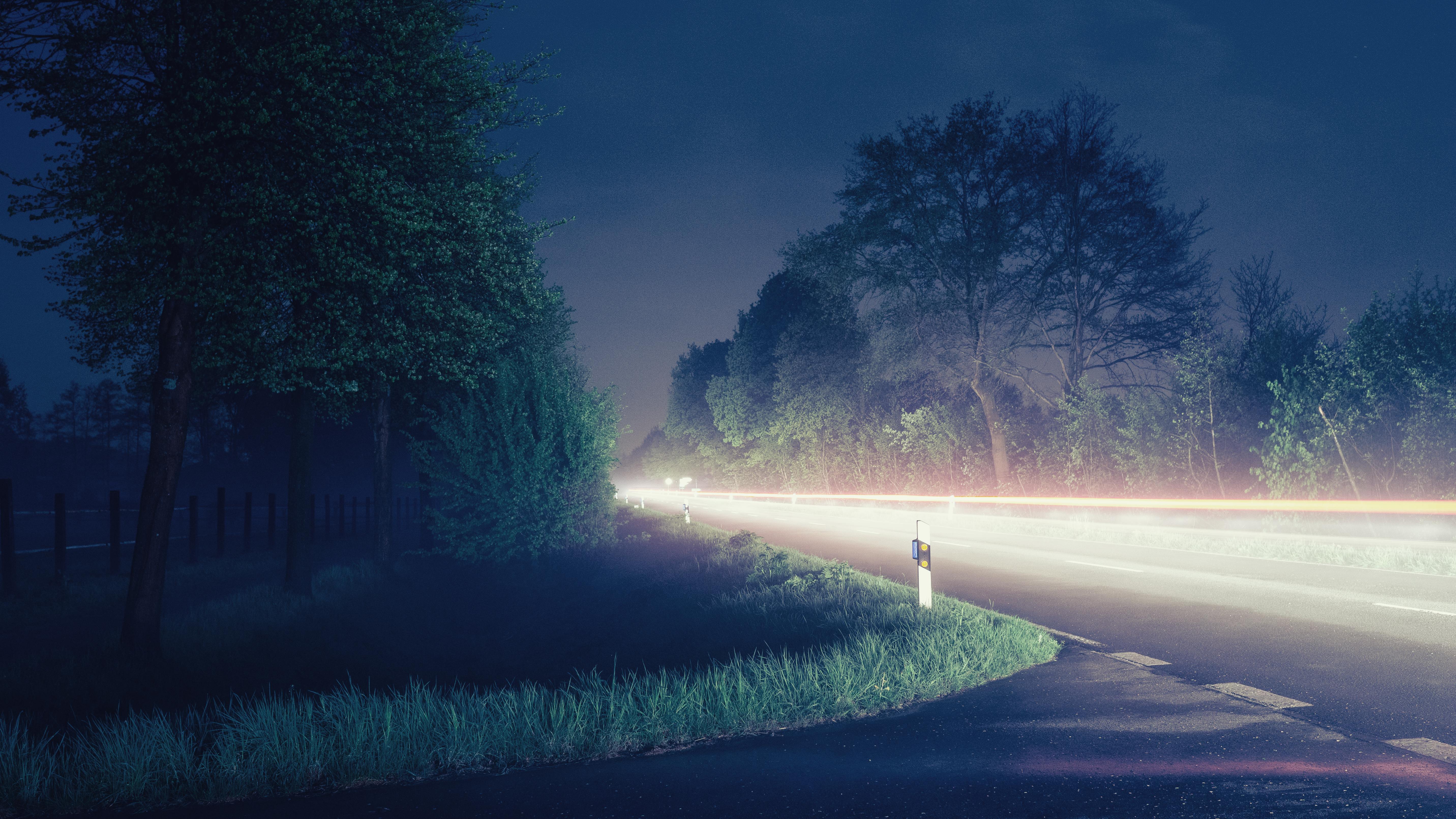 迷人的长曝光照片捕捉了德国北卡罗来纳州夜间乡村道路上宁静的车灯