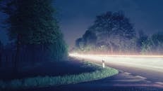 迷人的长曝光照片捕捉了德国北卡罗来纳州夜间乡村道路上宁静的车灯