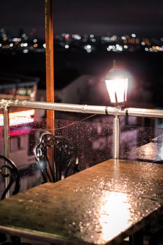 Cozy terrace in Istanbul after rain, with city lights and atmospheric ambiance.