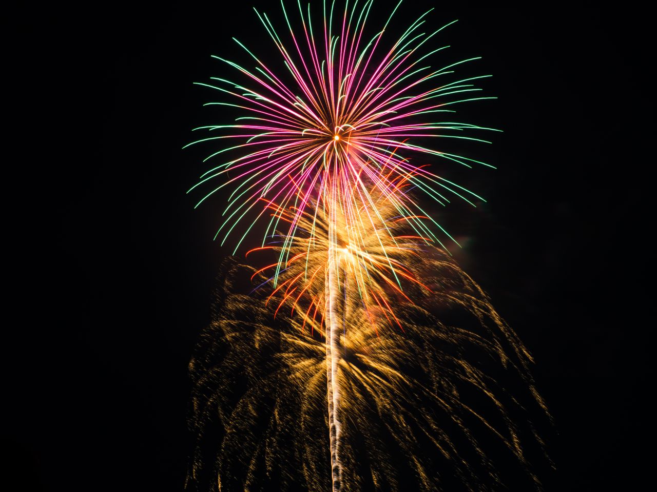colorful fireworks burst with vibrant trails celebrating a nighttime f