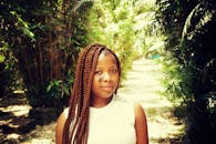 一位女士在阳光明媚的热带公园里轻松地享受一天