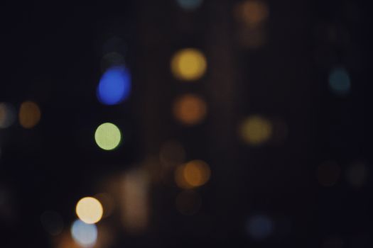Abstract bokeh lights against a dark background create a colorful night scene.