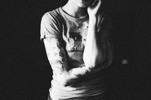 Grayscale Photo of a Tattooed Person 