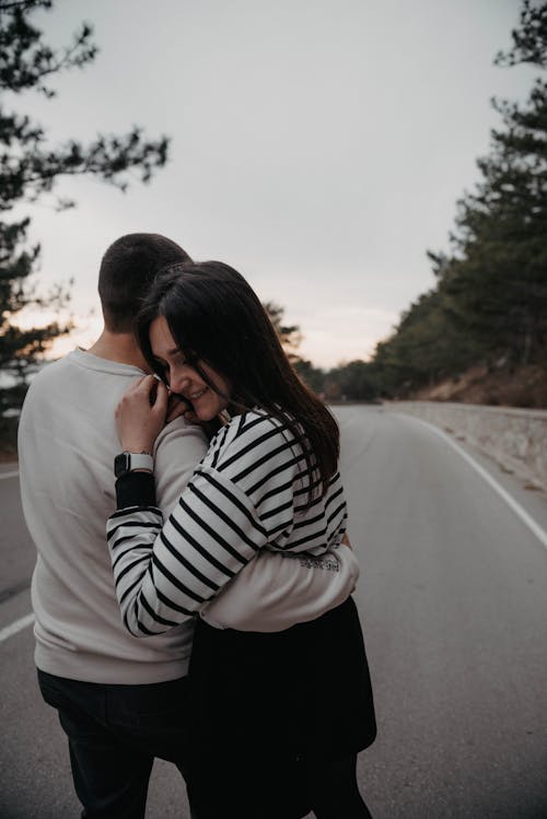 Free Photo of a Woman Smiling while Hugging a Man Stock Photo