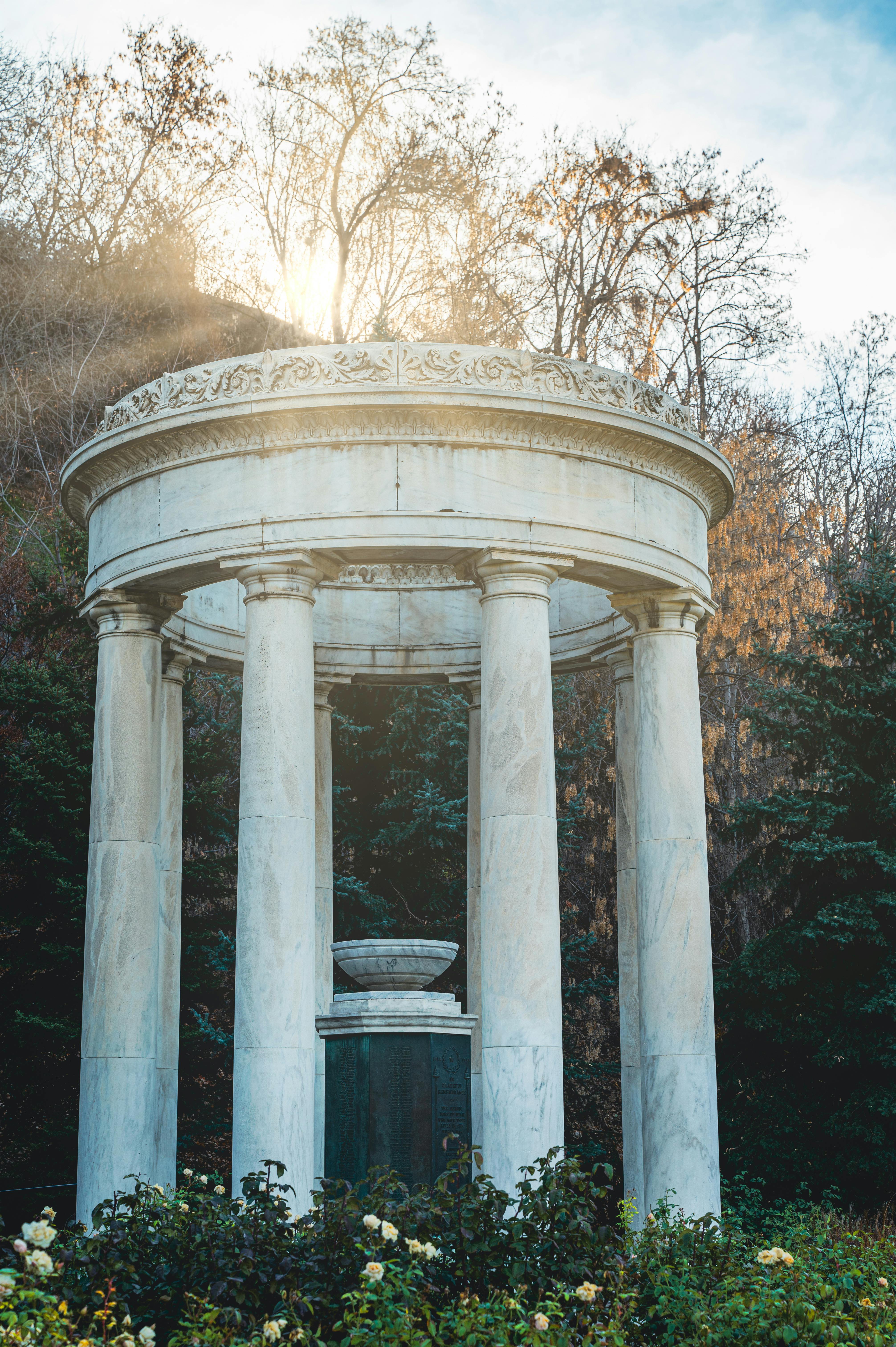 white concrete pillars near green trees