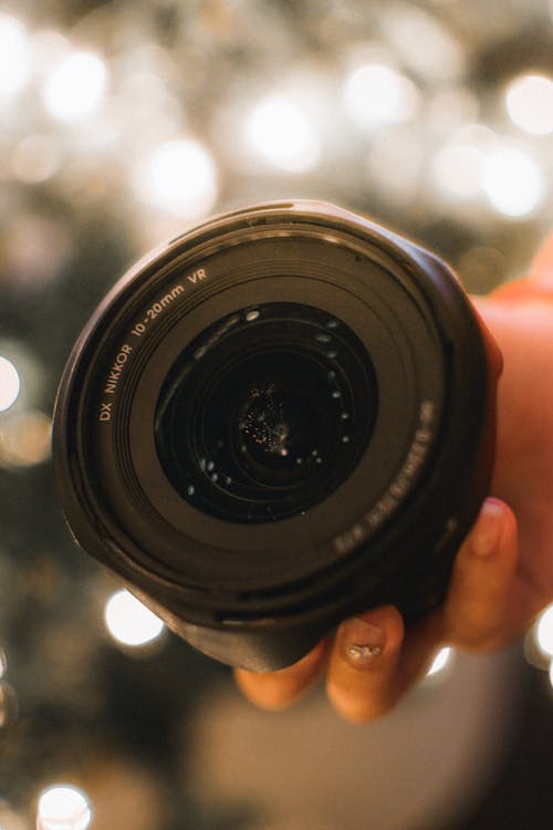 Person Holding Black Camera Lens