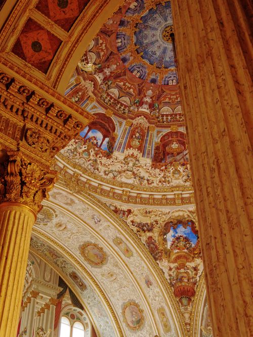 Free Detailed view of a cathedral's ornate ceiling and architectural elements, showcasing rich artistry. Stock Photo