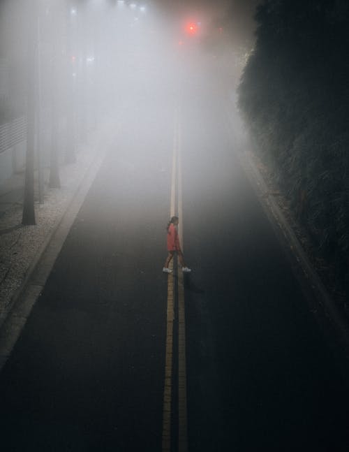 Woman Crossing the Asphalt Road