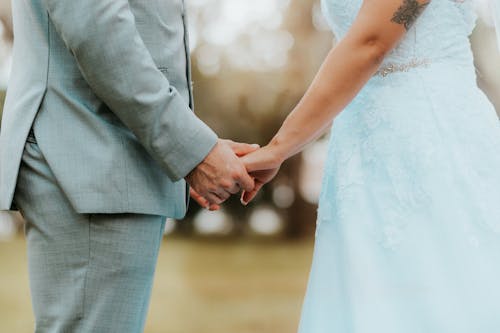 Kostenloses Stock Foto zu anzug, händchen halten, hochzeitskleid