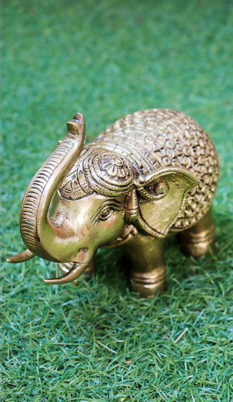 Gold Elephant Figurine On A Grassy Ground