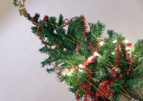 Top of a Christmas tree with red tinsel and fairy lights