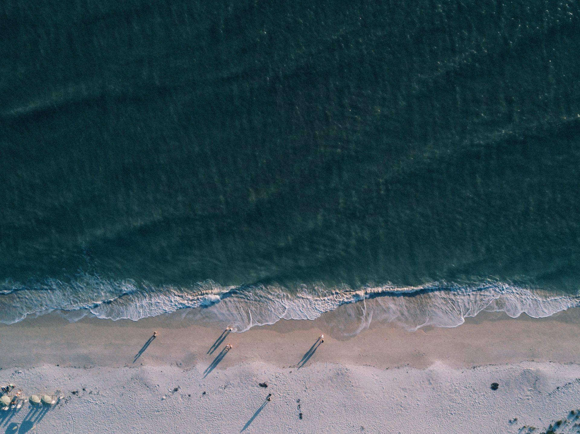 A breathtaking aerial view of a tranquil beach with gentle ocean waves and sandy shore.
