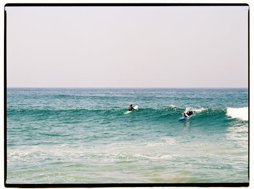 People Surfing on the Sea