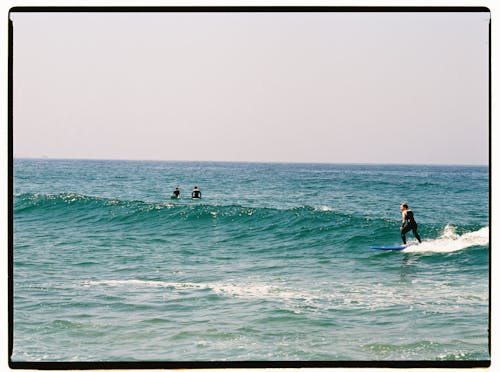 Free People Surfboarding on the Sea Stock Photo