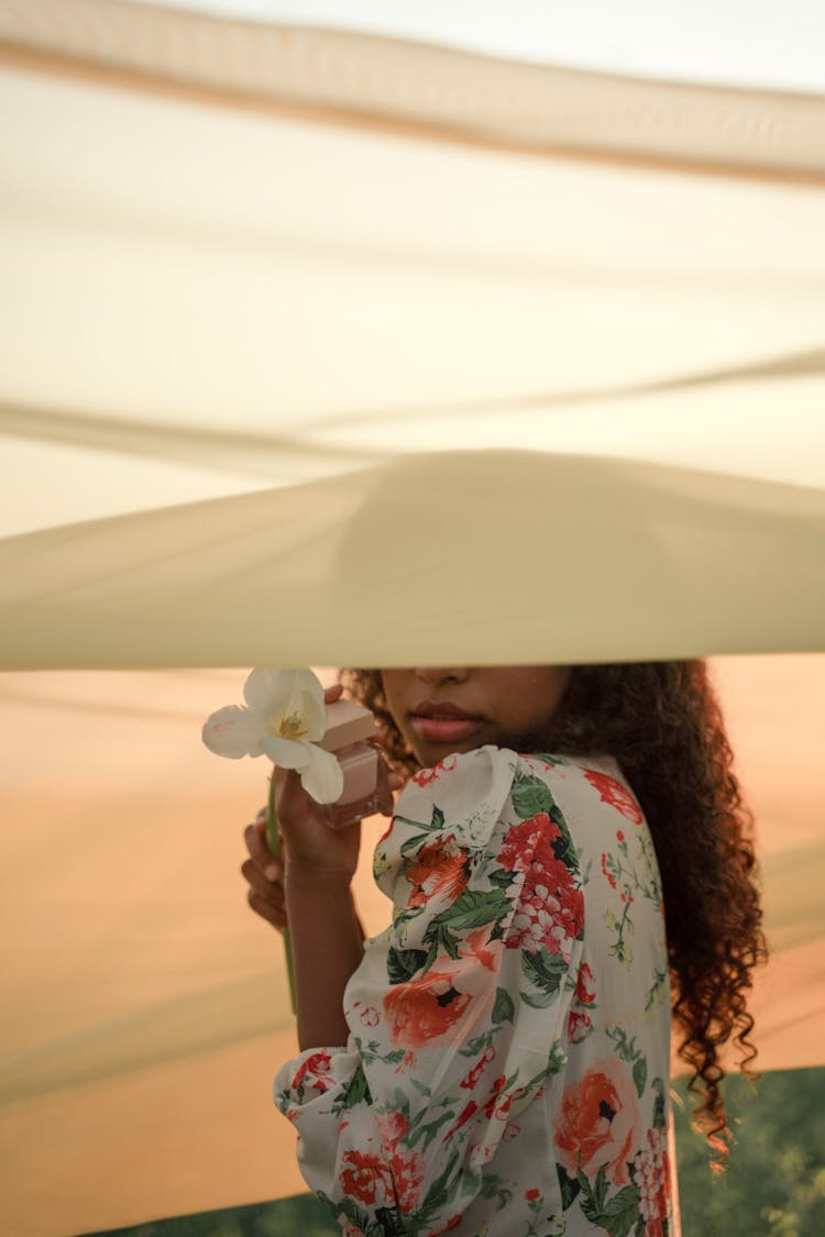 Woman Covered By Tulle Fabric Holding Flower And Perfume Container In Hands