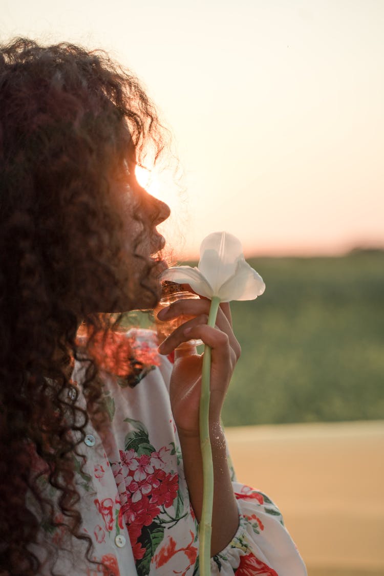 Profile View Of Woman With Curly Long Hair Holding Big White Flower