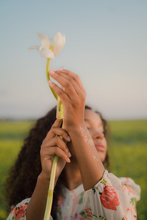 Woman Standing in Field Holding White Flower and Glass Testing Tube