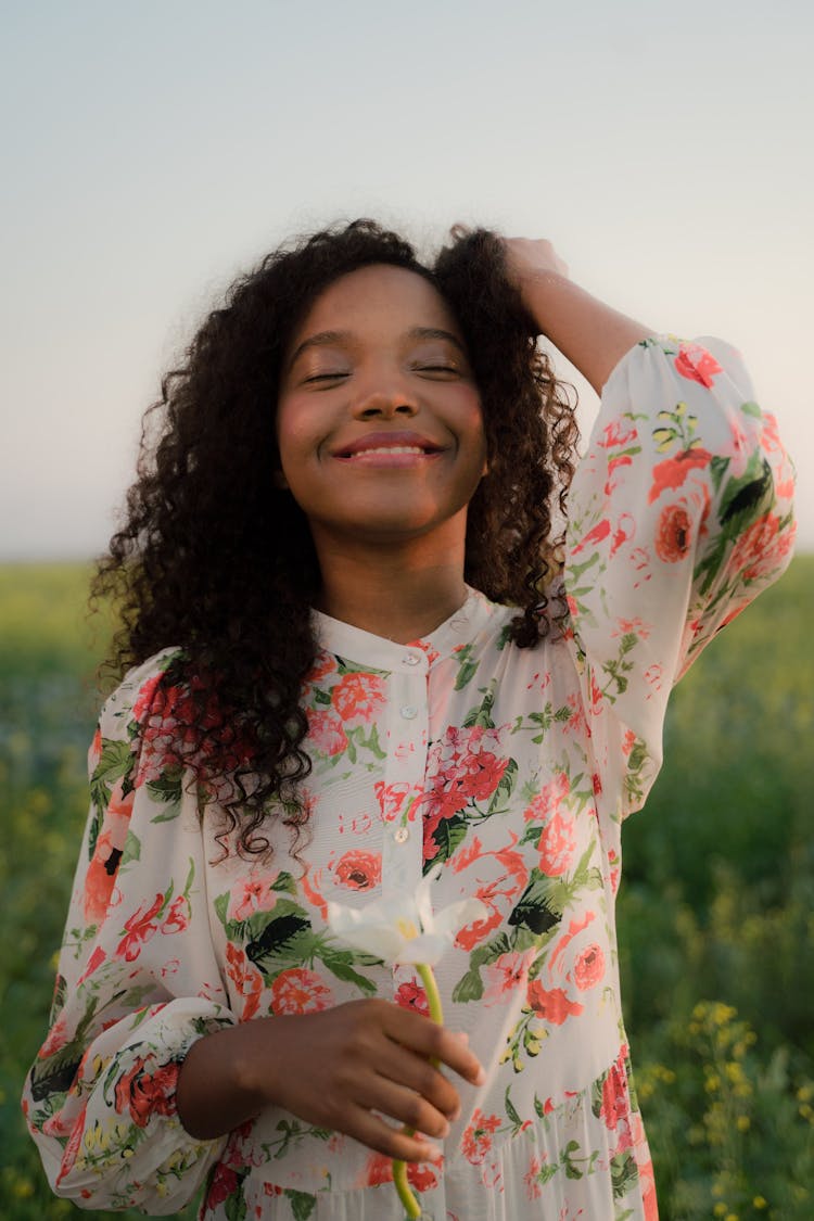 Young Pretty Woman With Long Wavy Hair Standing With Eyes Closed And Smiling