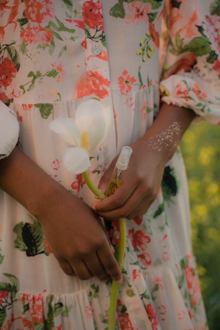 Unrecognizable Female Hands Holding Big White Flower And Tiny Perfume Spray Bottle