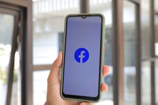 Close-up of smartphone with Facebook app open held by hand indoors.