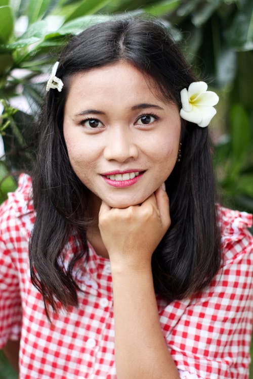 Free Portrait of a Woman Smiling with a Flower on Her Ear Stock Photo
